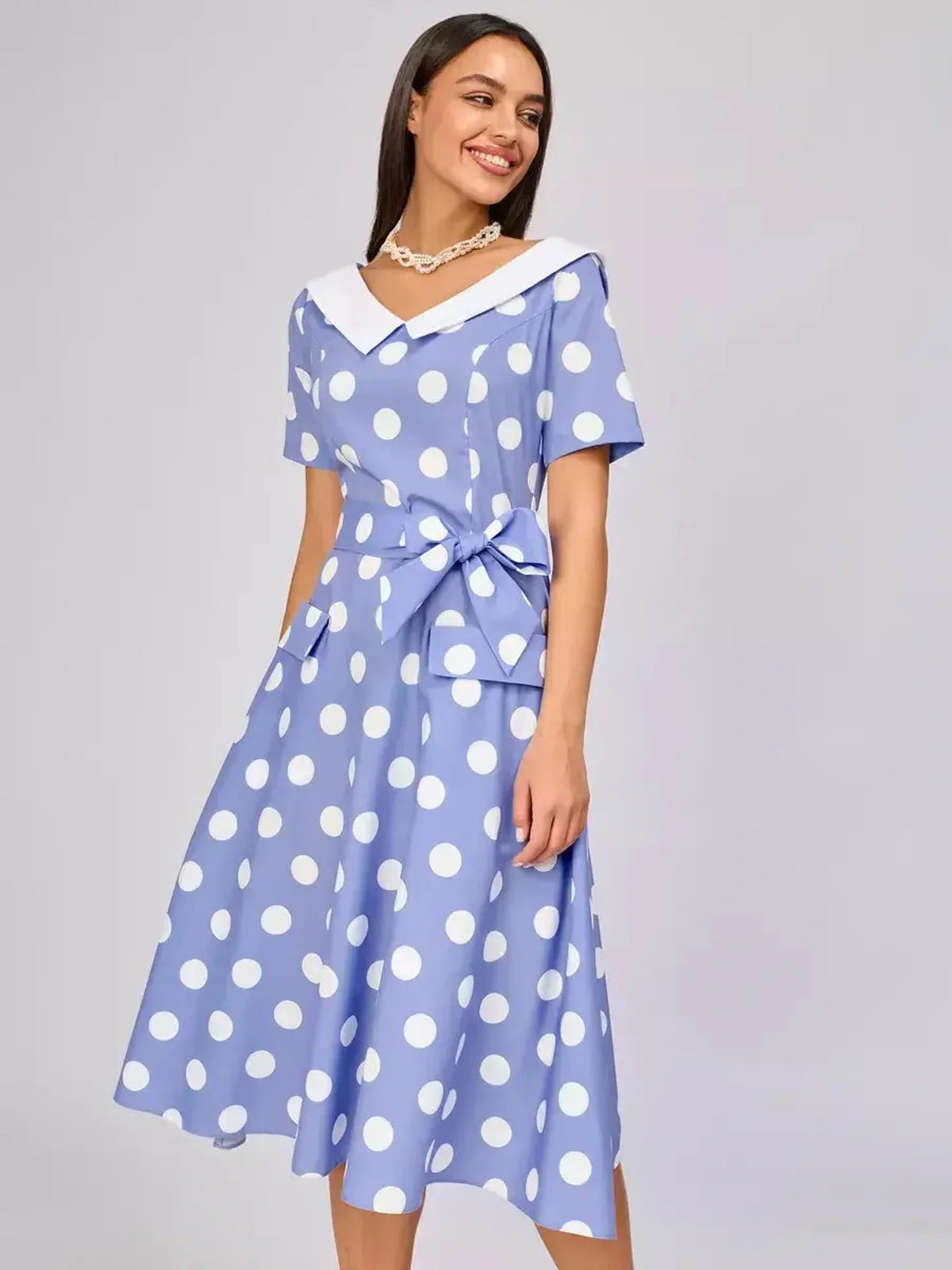 Sky-blue midi dress with white polka dots, contrast collar, and waist tie, perfect for summer weddings and formal occasions.