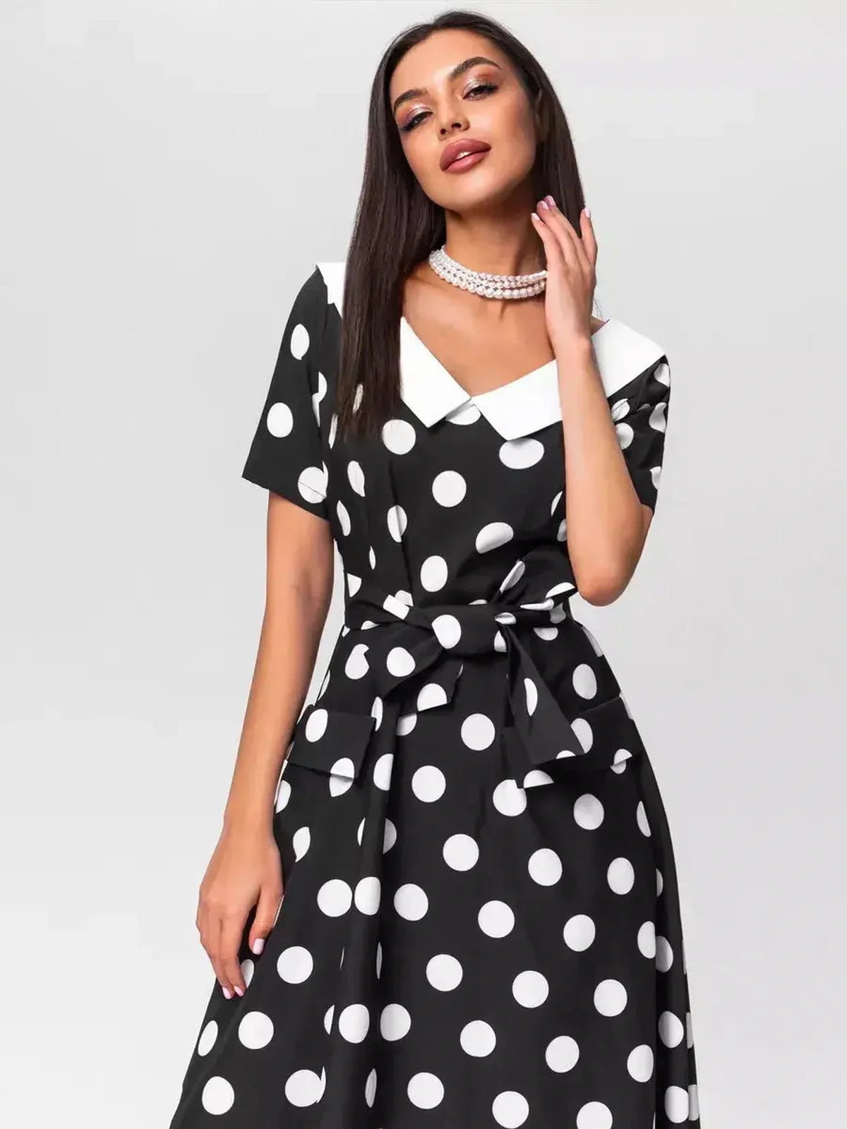 Elegant midi dress Luna Dot featuring polka dots and a flattering V-neckline with white collar, ideal for summer occasions.