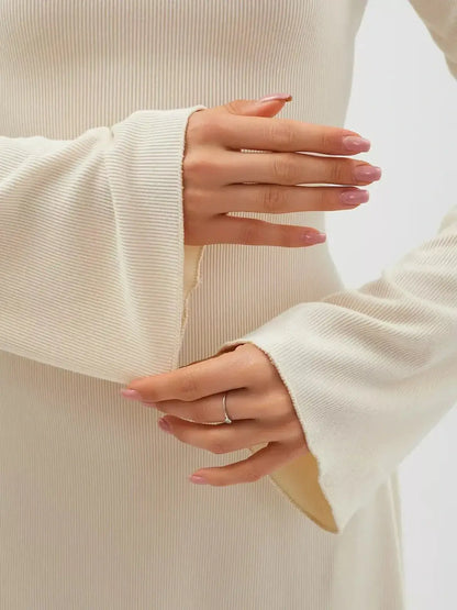 Close-up of hands adjusting flared sleeves on a Vanilla Flare Mini Dress in elegant ribbed knit for women.