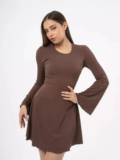 Model wearing a Cocoa Tie Mini Dress with flared sleeves, showcasing its sculpted knit and adjustable back detail.