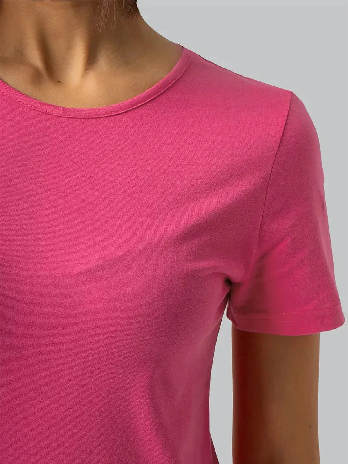 Close-up of a pink cotton crew neckline, showcasing the Breeze Midi Dress's soft fabric and playful style.