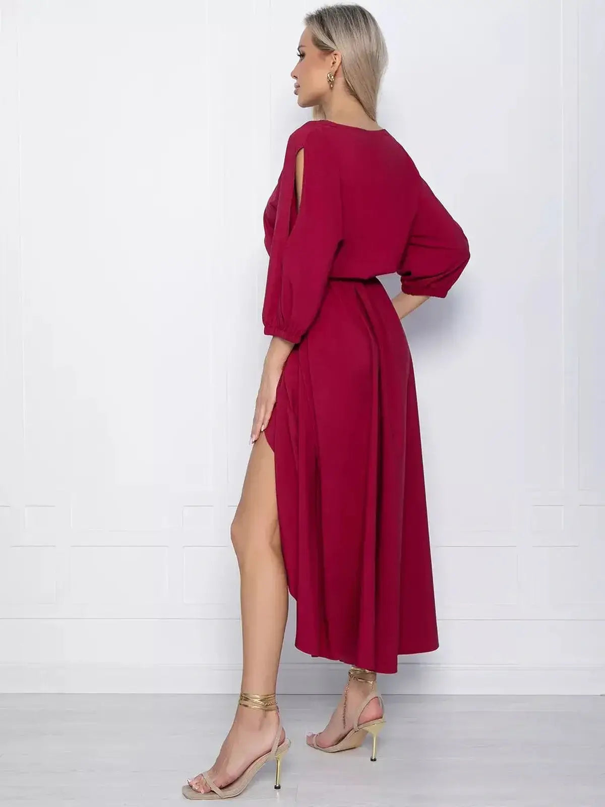 Elegant crimson midi dress featuring a high-low hem and dramatic slit, perfect for weddings and special occasions.
