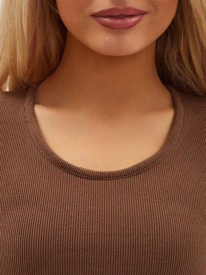 Close-up of a woman wearing a cocoa-colored, ribbed dress neckline showcasing chic, minimalist style.