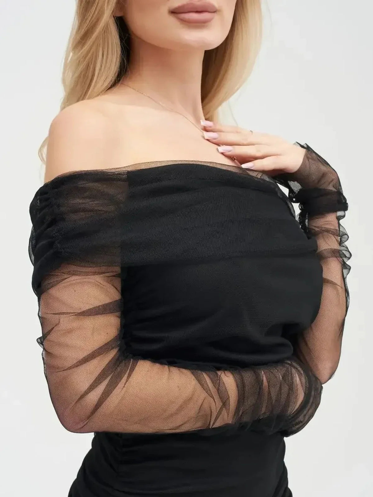 Off-shoulder black velour midi dress with sheer mesh sleeves, embodying elegance and sophistication.