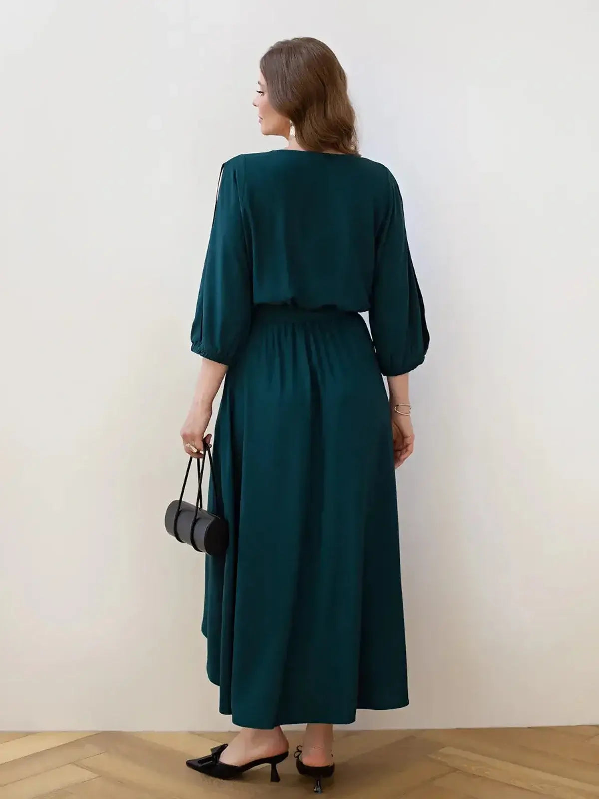 Back view of a woman in a teal Cascade Midi Dress, featuring soft draping and elegant shoulder cutouts.