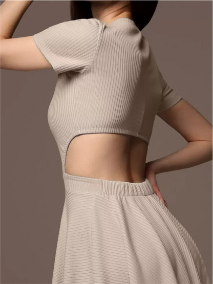 Close-up of a woman modeling a beige Breezy Hour mini dress with a unique open back design and short sleeves.
