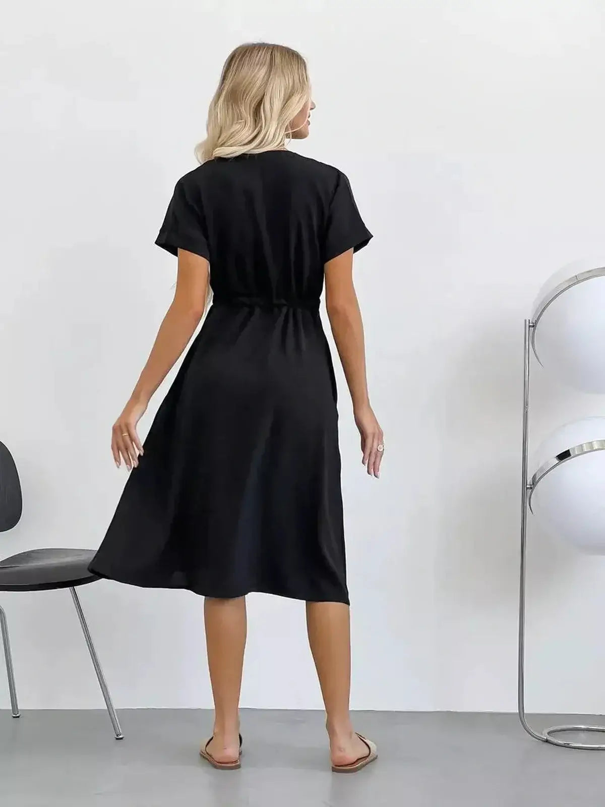 Elegant black midi dress with a tie waist and breezy sleeves, perfect for summer weddings and casual outings.