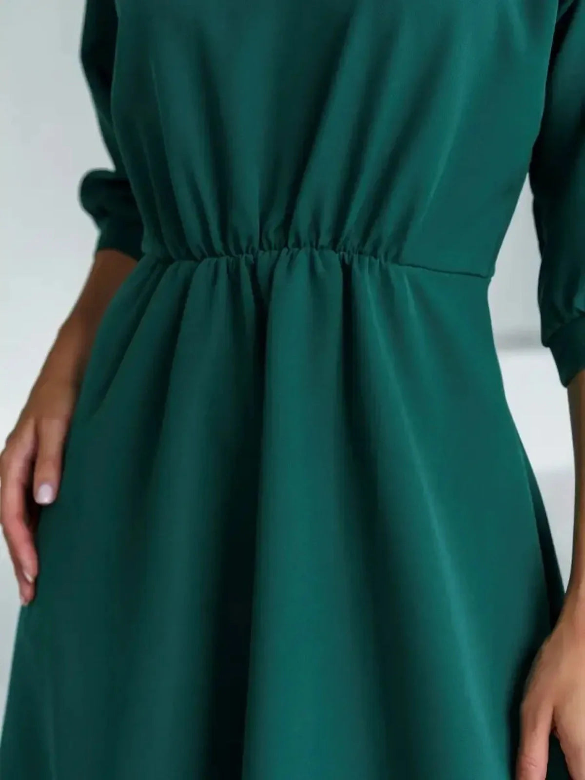 Close-up of the Emerald Aura Midi Dress highlighting the belted waist and flowing A-line silhouette in jewel-tone green.