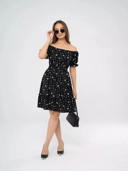 Woman in an off-shoulder black floral dress, perfect for summer events or weddings, stylishly paired with sunglasses.