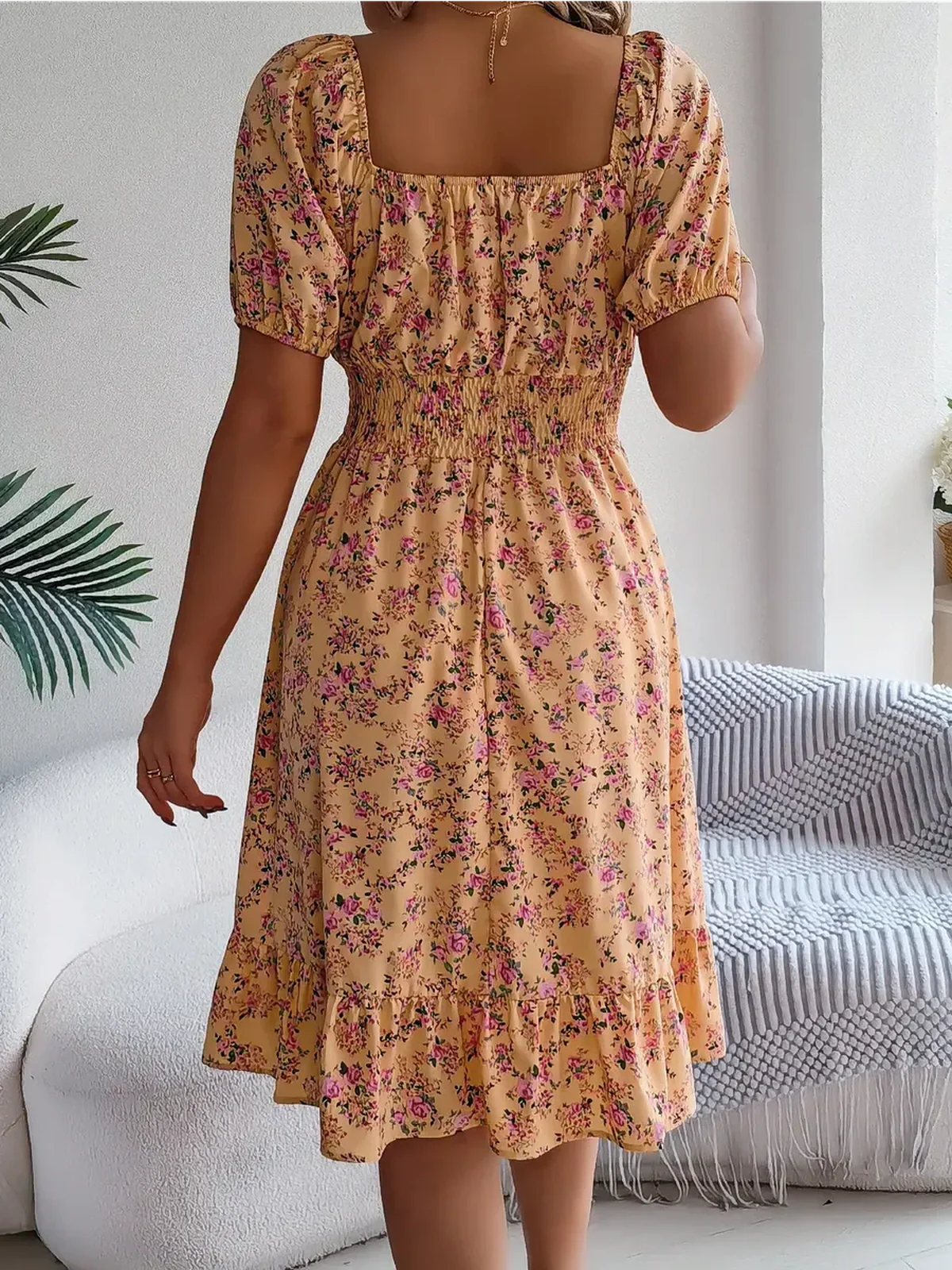 Back view of the Marigold Bloom floral midi dress showcasing puff sleeves and smocked waist, perfect for summer occasions.