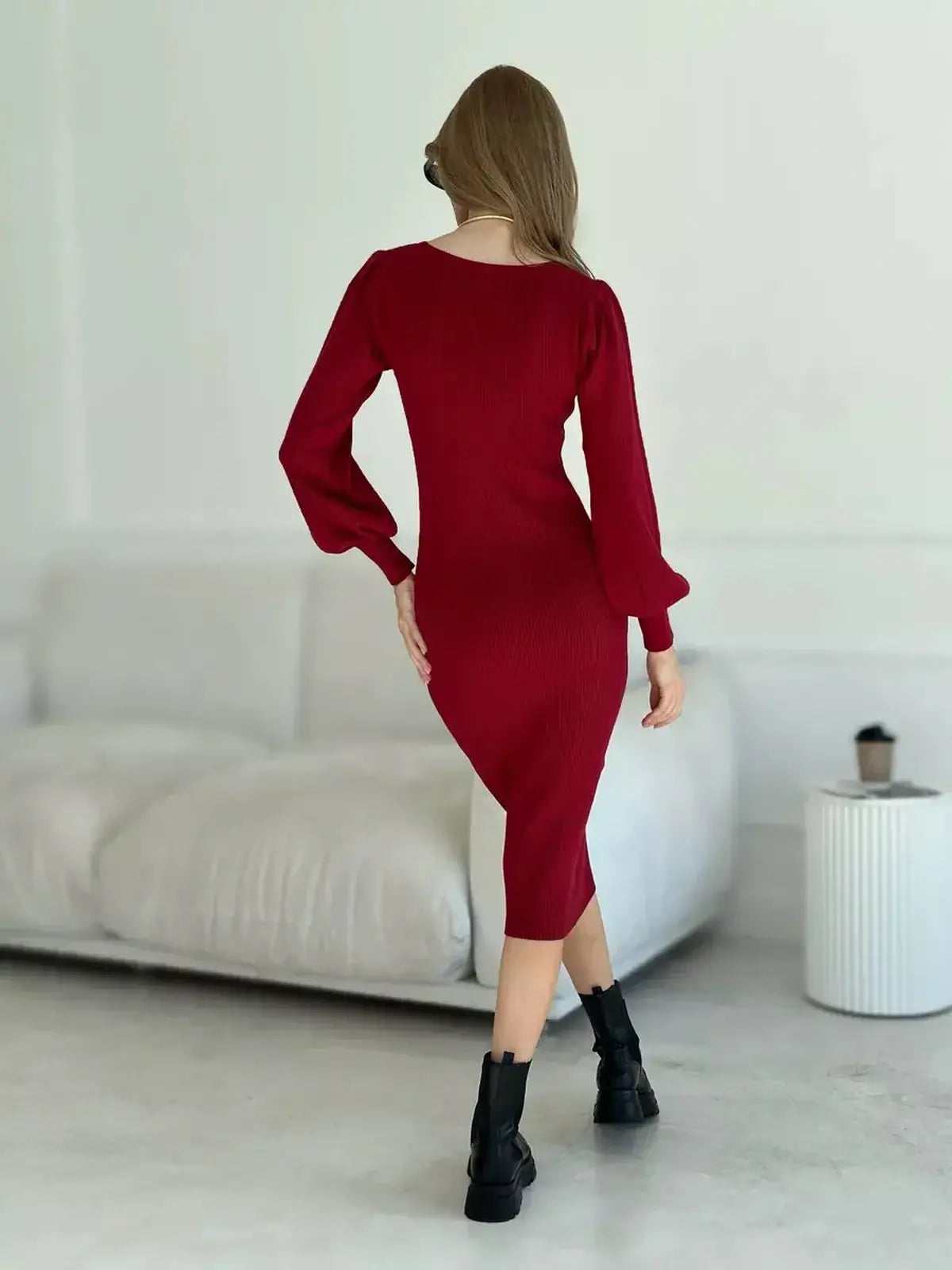 Woman in a red ribbed knit midi dress with sculpted sleeves, showcasing an elegant silhouette perfect for evening wear.