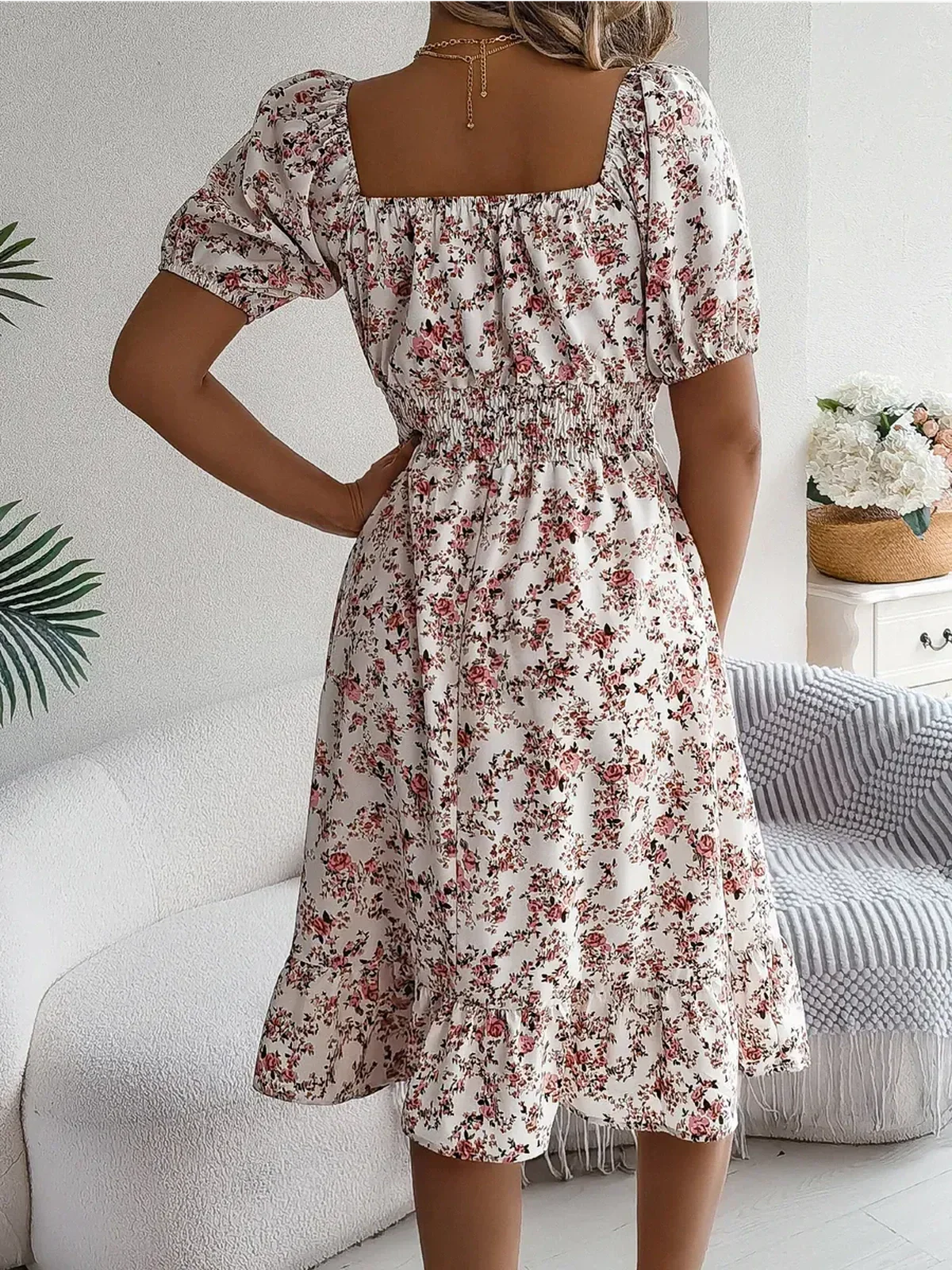 Back view of Rosalie Bloom summer dress featuring a square neckline, puff sleeves, and floral print in blush and cream.