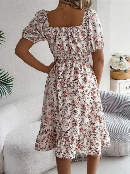 Back view of Rosalie Bloom summer dress featuring a square neckline, puff sleeves, and floral print in blush and cream.