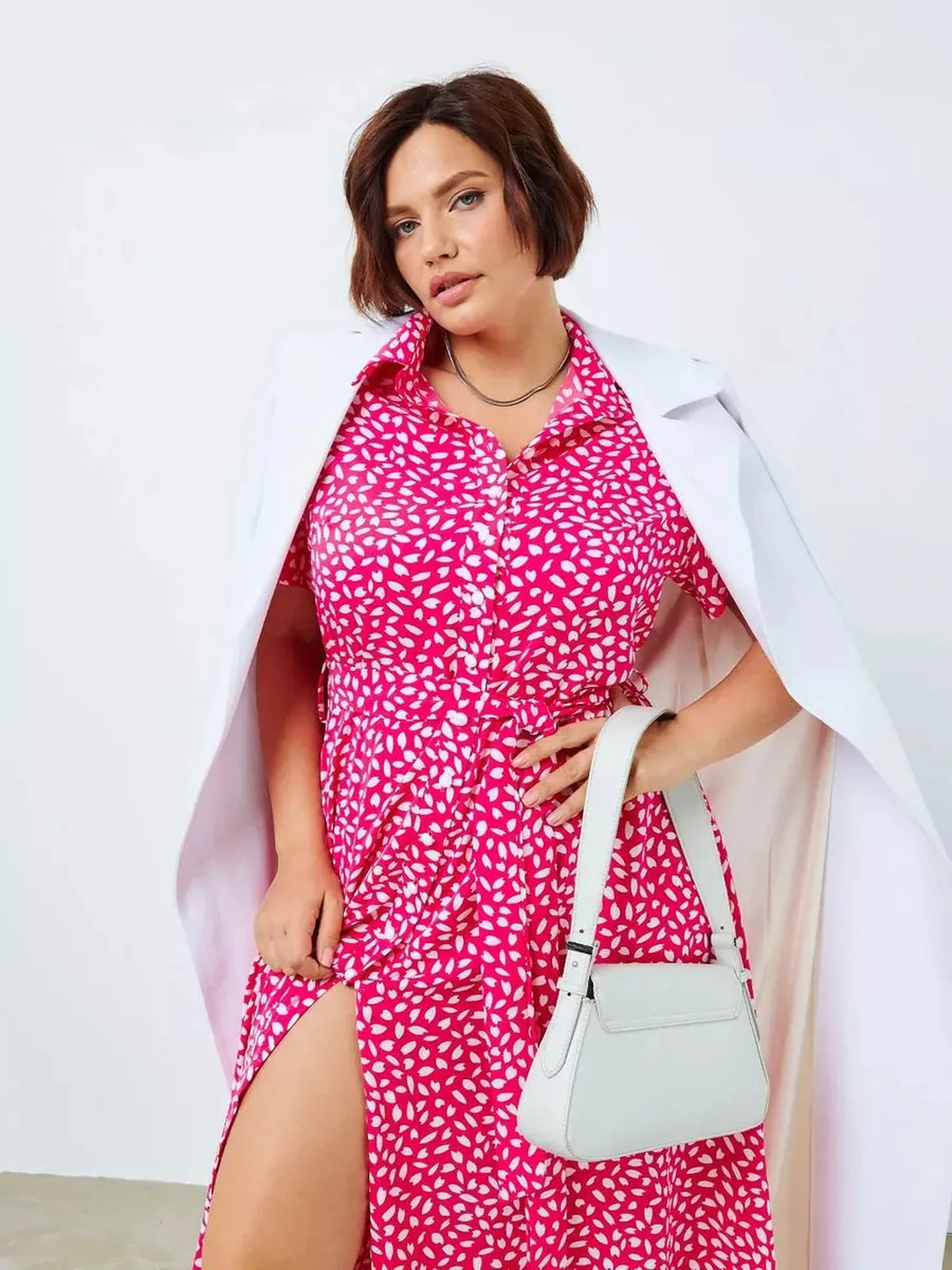 Curvy model showcasing the vibrant pink Petal Pop Midi Dress with white petal print, perfect for summer events or casual outings.
