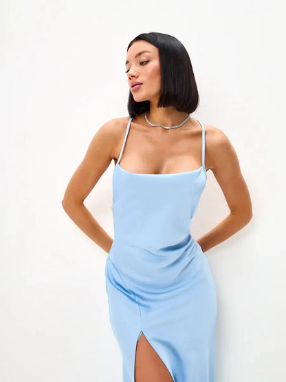Model wearing an Icy Glow Midi Dress in light blue with a cowl neckline and thigh-high slit for summer occasions.