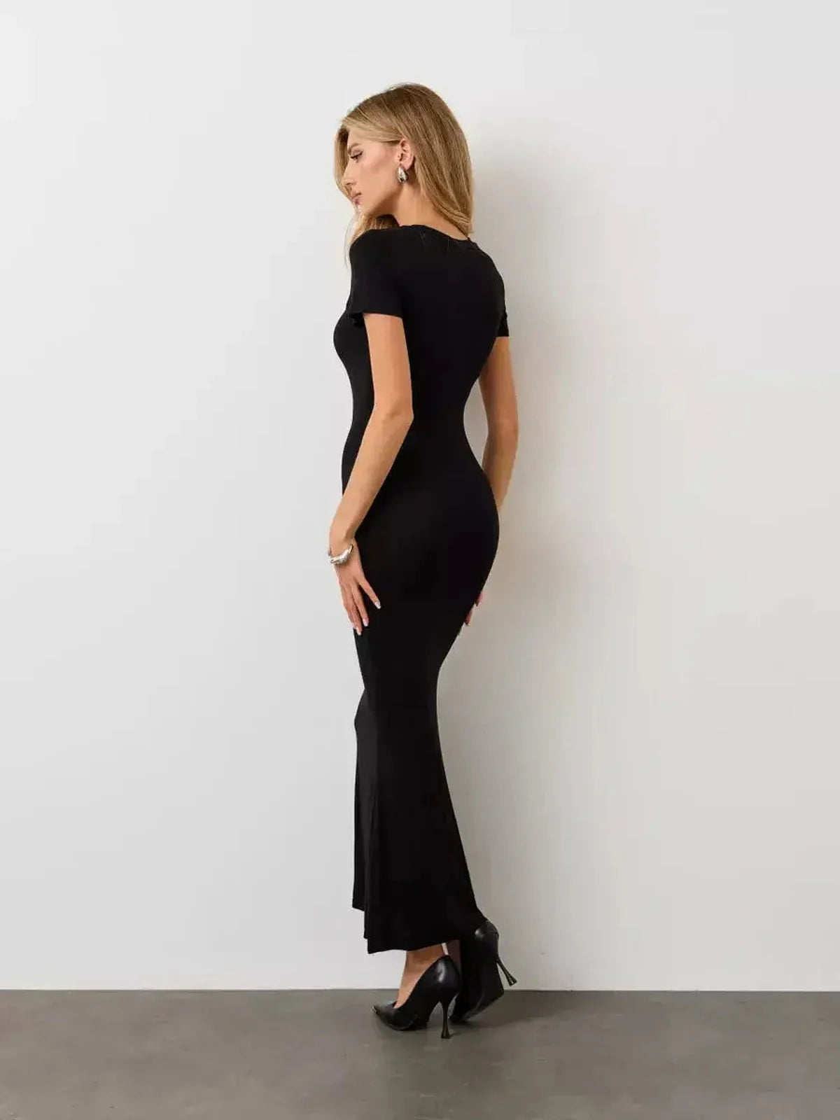 Noir Curve Maxi Dress in black, featuring a sculpted silhouette, short sleeves, and a flared maxi hem, perfect for various occasions.