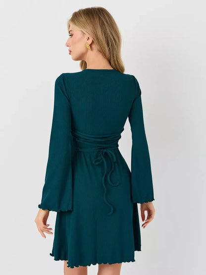 Emerald Whisper mini dress featuring a flared hem and fluted sleeves, ideal for wedding guests and summer events.