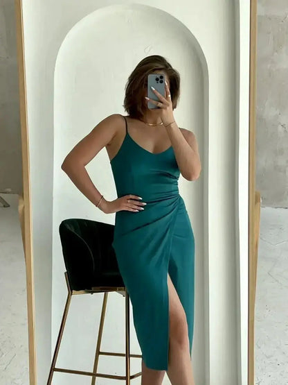 Sleek emerald green Lustre Midi Dress featuring a thigh-high slit, perfect for wedding guest outfits or evening soirées.