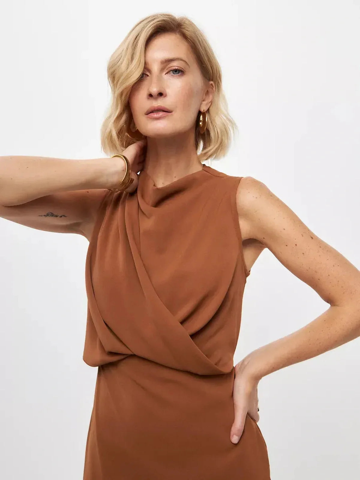 Model showcasing the Sculpted Drape Maxi Dress in warm light brown, perfect for formal occasions and weddings.