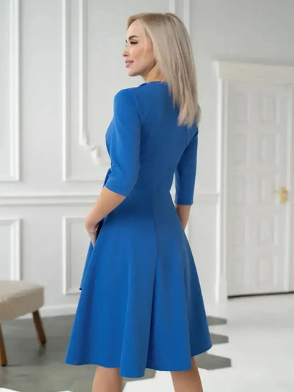Back view of a woman in a striking royal blue midi dress showcasing draped wrap elegance.