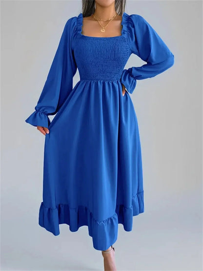 Blue Serena Midi Dress featuring smocked bodice, ruffled hem, and long sleeves, perfect for weddings and formal events.