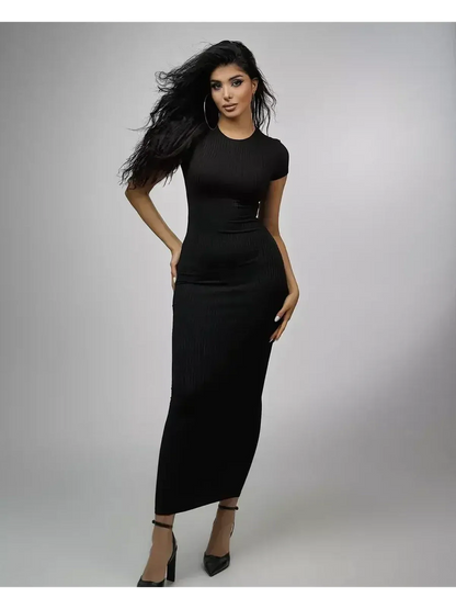 Model showcasing the Obsidian Maxi Dress, a sleek black ribbed knit dress perfect for weddings and formal events.