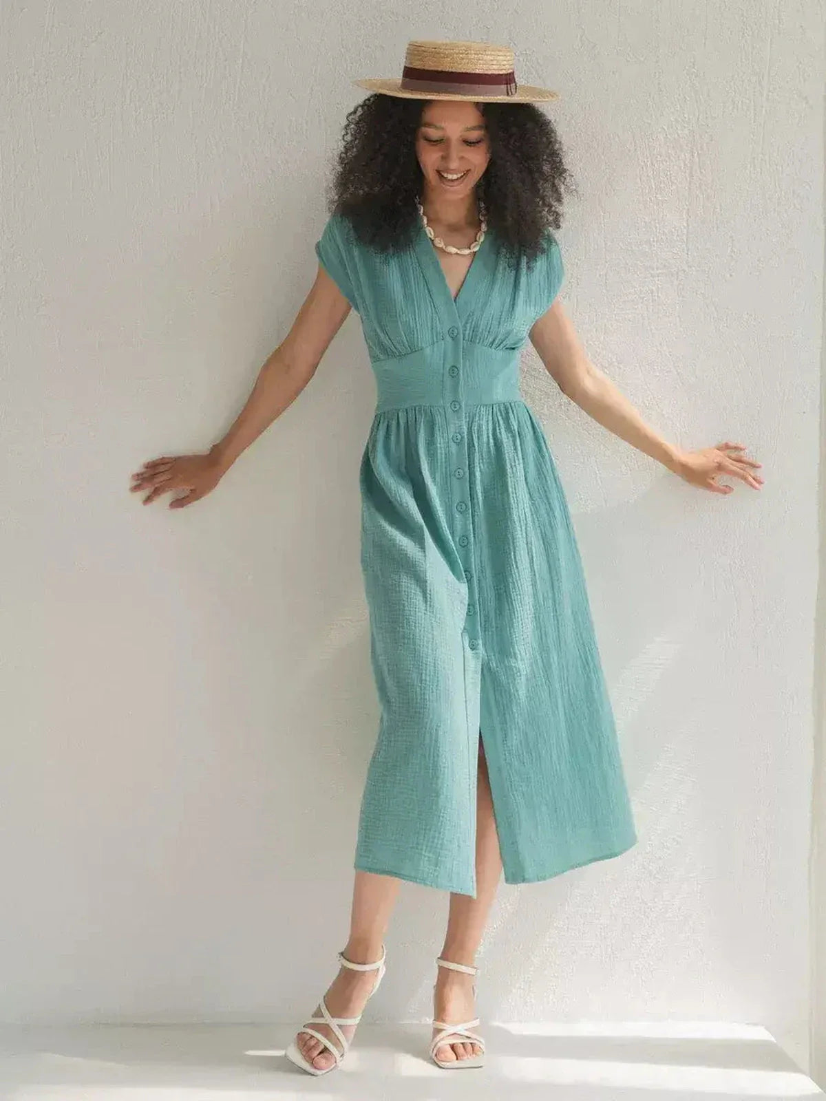 Model wearing a sea-green Veranda Midi Dress with a corset waist and V-neckline, perfect for summer occasions.