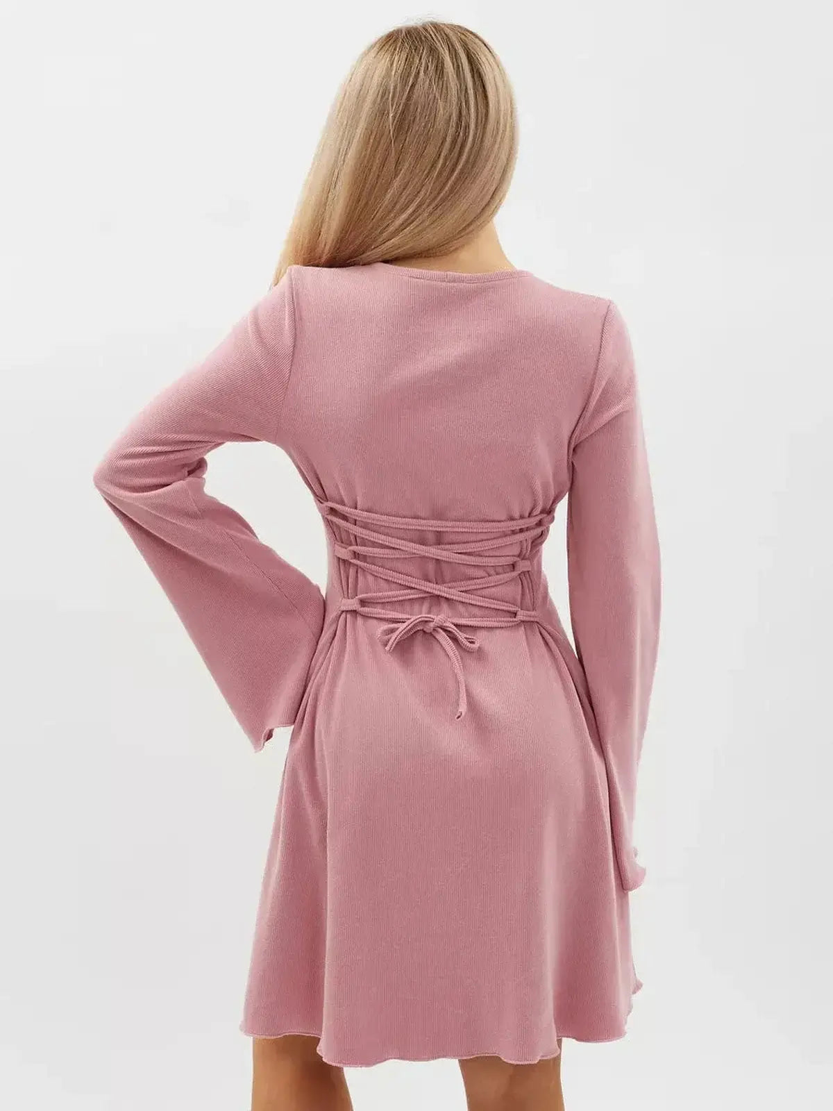 Back view of a pink Rose Tie Mini Dress with flared sleeves and lace-up waist, perfect for warm-weather occasions.