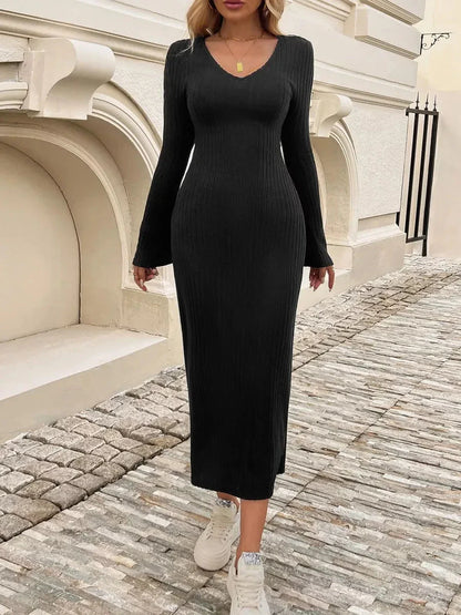 Model wears a Sculpted Chic Midi Dress in black, featuring ribbed knit fabric, bell sleeves, and a flared cuff for elegant style.