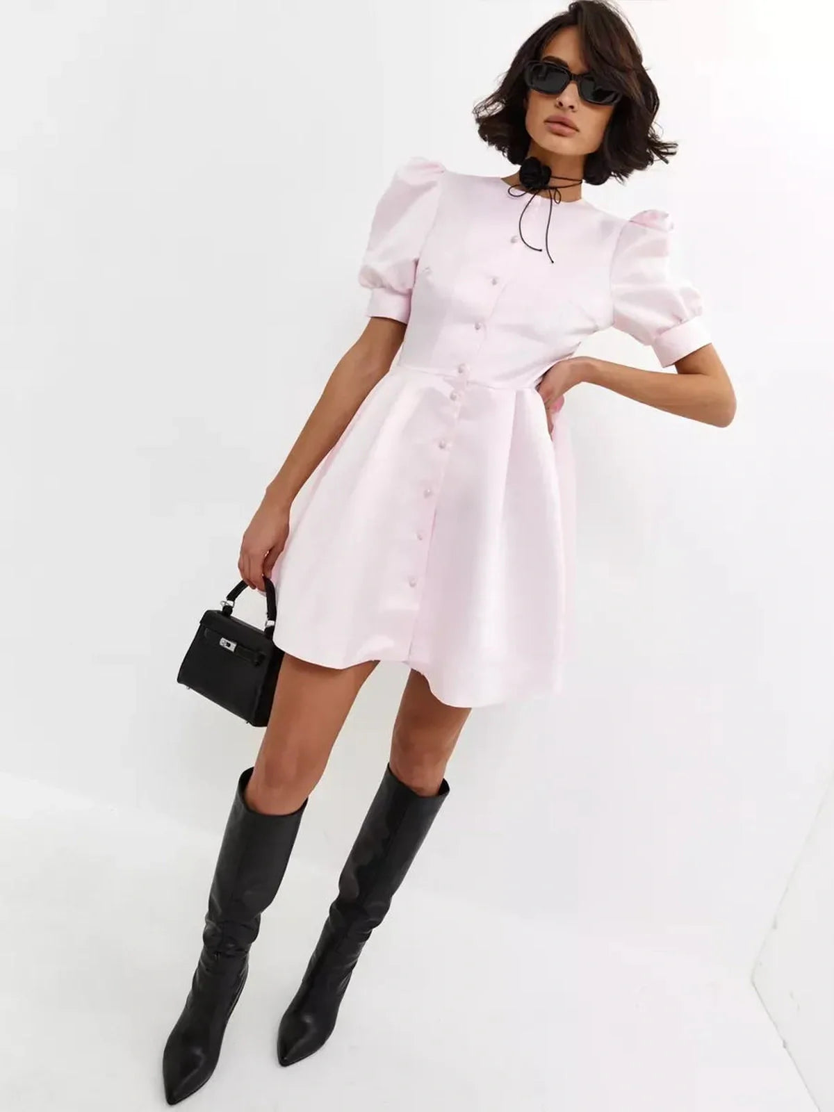 Model showcasing a pink Pearl Puff Mini Dress with voluminous sleeves and satin finish, perfect for summer events.