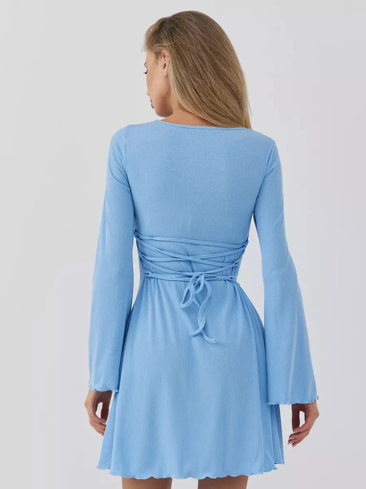 Back view of a sky blue mini dress showcasing a cinched waist and flowing sleeves, perfect for summer events.