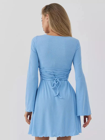 Back view of a sky blue mini dress showcasing a cinched waist and flowing sleeves, perfect for summer events.