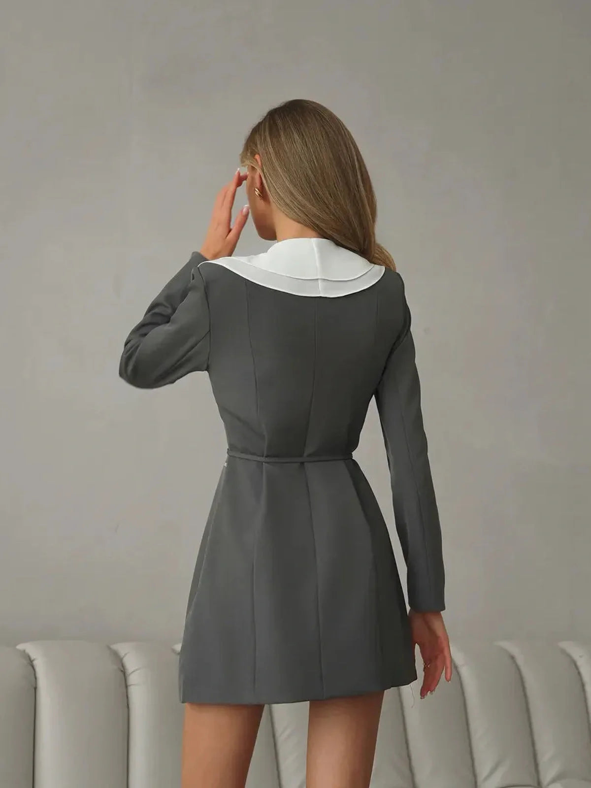 Back view of a feminine long sleeve mini dress featuring a white collar and ruffle detail, perfect for summer and wedding guest occasions.