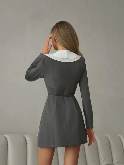 Back view of a feminine long sleeve mini dress featuring a white collar and ruffle detail, perfect for summer and wedding guest occasions.
