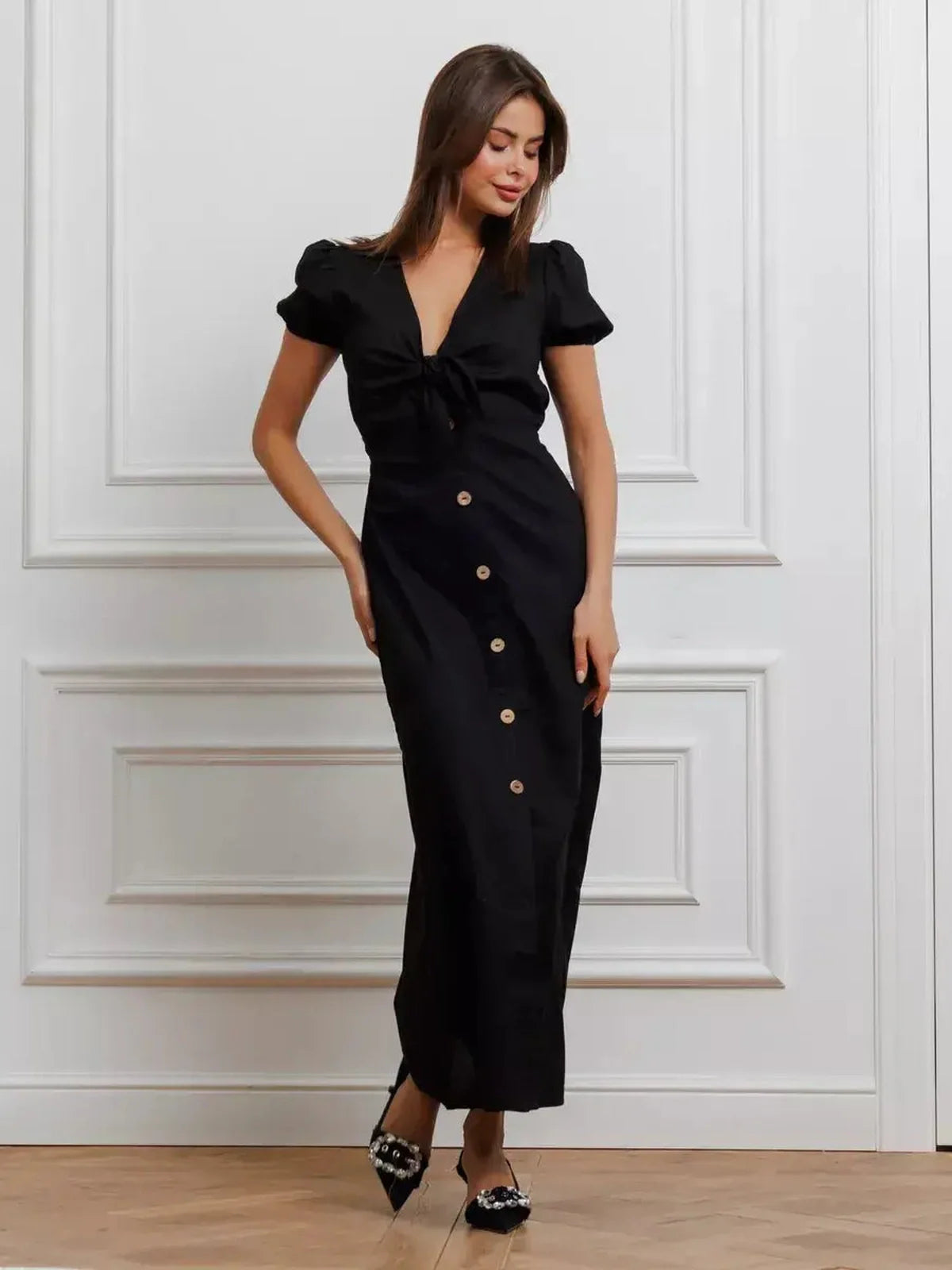 Elegant black maxi dress with tie-front detail and puff sleeves, perfect for weddings or formal events.