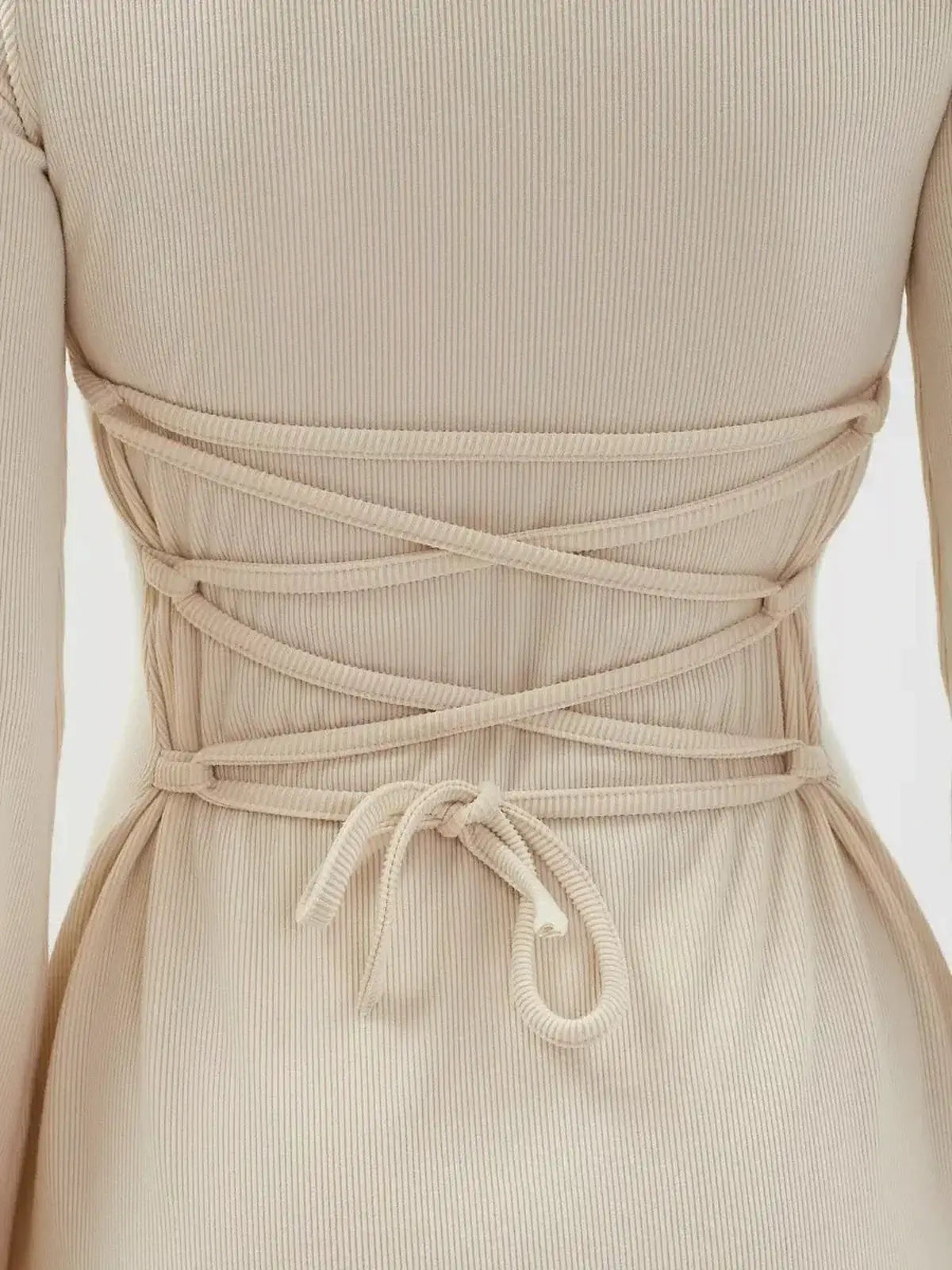 Back view of the Vanilla Flare Mini Dress showcasing its stylish crisscross tie and ribbed knit texture.