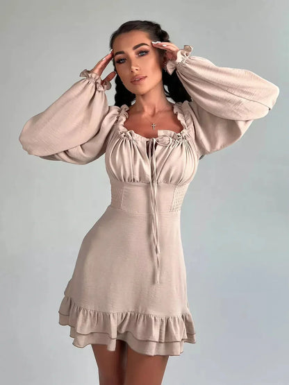 Beige off-shoulder Ruffle Muse Mini Dress with puff sleeves and flounced hem, perfect for summer parties.