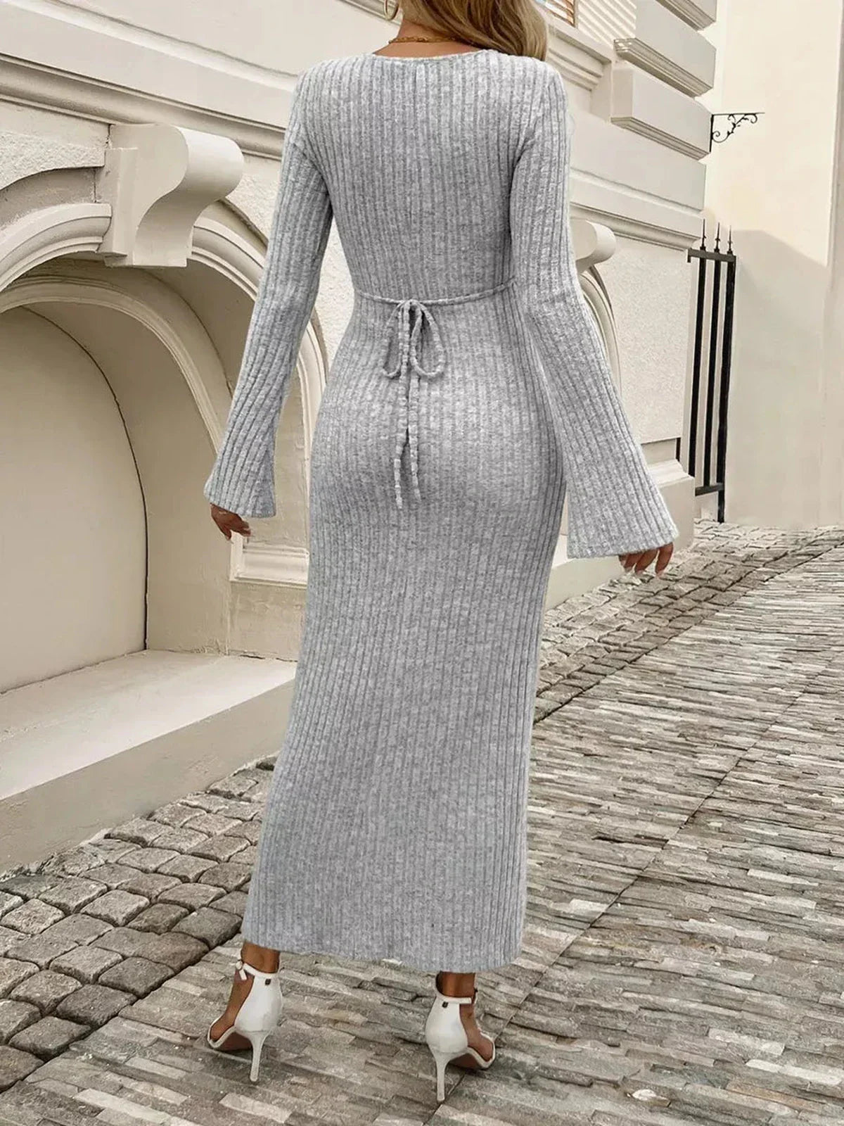Back view of a woman in a gray ribbed knit midi dress with flared sleeves, ideal for casual or formal occasions.