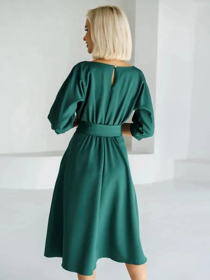 Elegant back view of the Emerald Aura Midi Dress in jewel-tone green, showcasing a belted waist and stylish boat neckline.