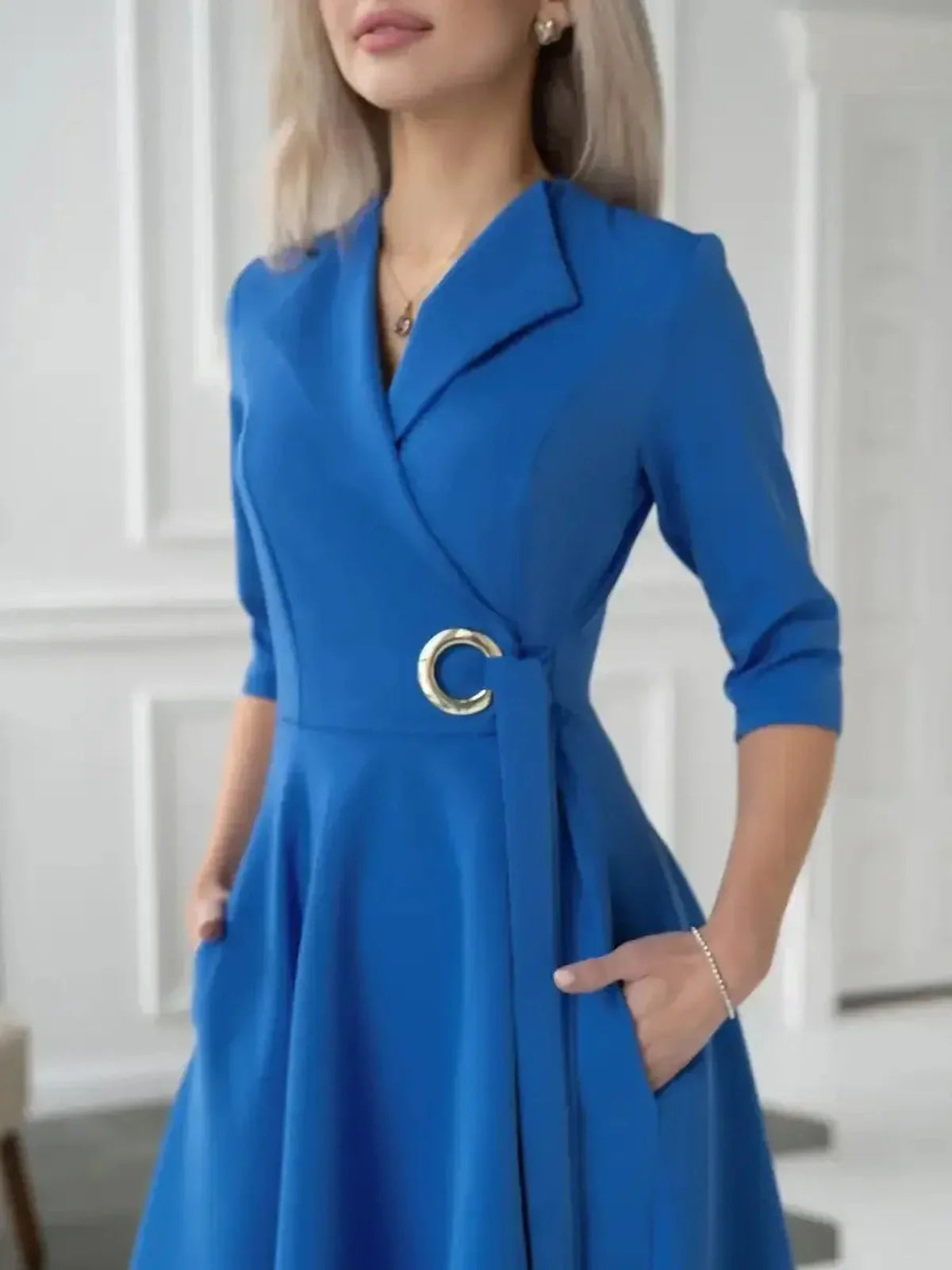 Sapphire Flow Midi Dress in royal blue with a draped wrap silhouette and metallic waist detail for modern elegance.