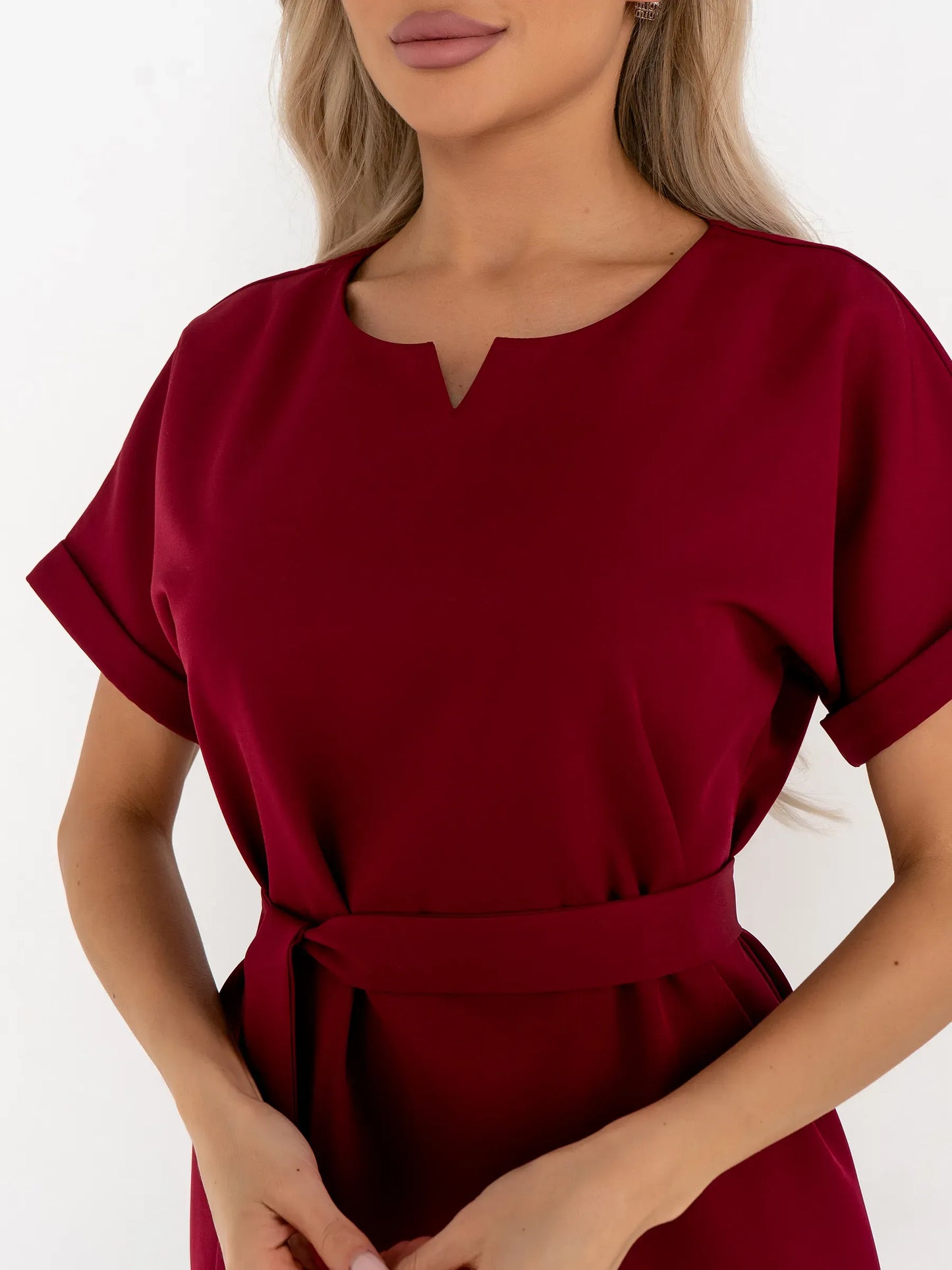 Close-up of a woman wearing a crimson mini dress with a notched neckline and a detachable belt, ideal for weddings and parties.