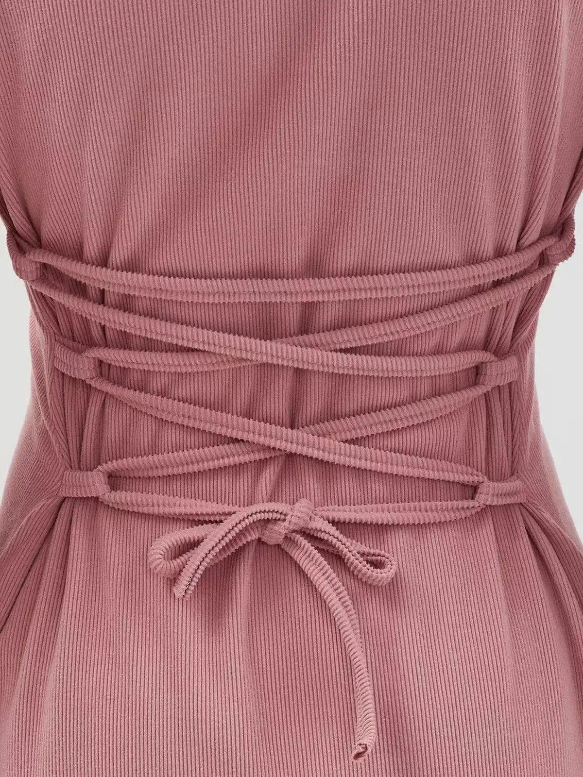 Close-up of the lace-up waist detail on a Rose Tie Mini Dress in pink, showcasing its flared silhouette and sculpted knit.
