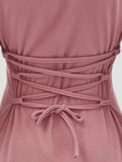 Close-up of the lace-up waist detail on a Rose Tie Mini Dress in pink, showcasing its flared silhouette and sculpted knit.
