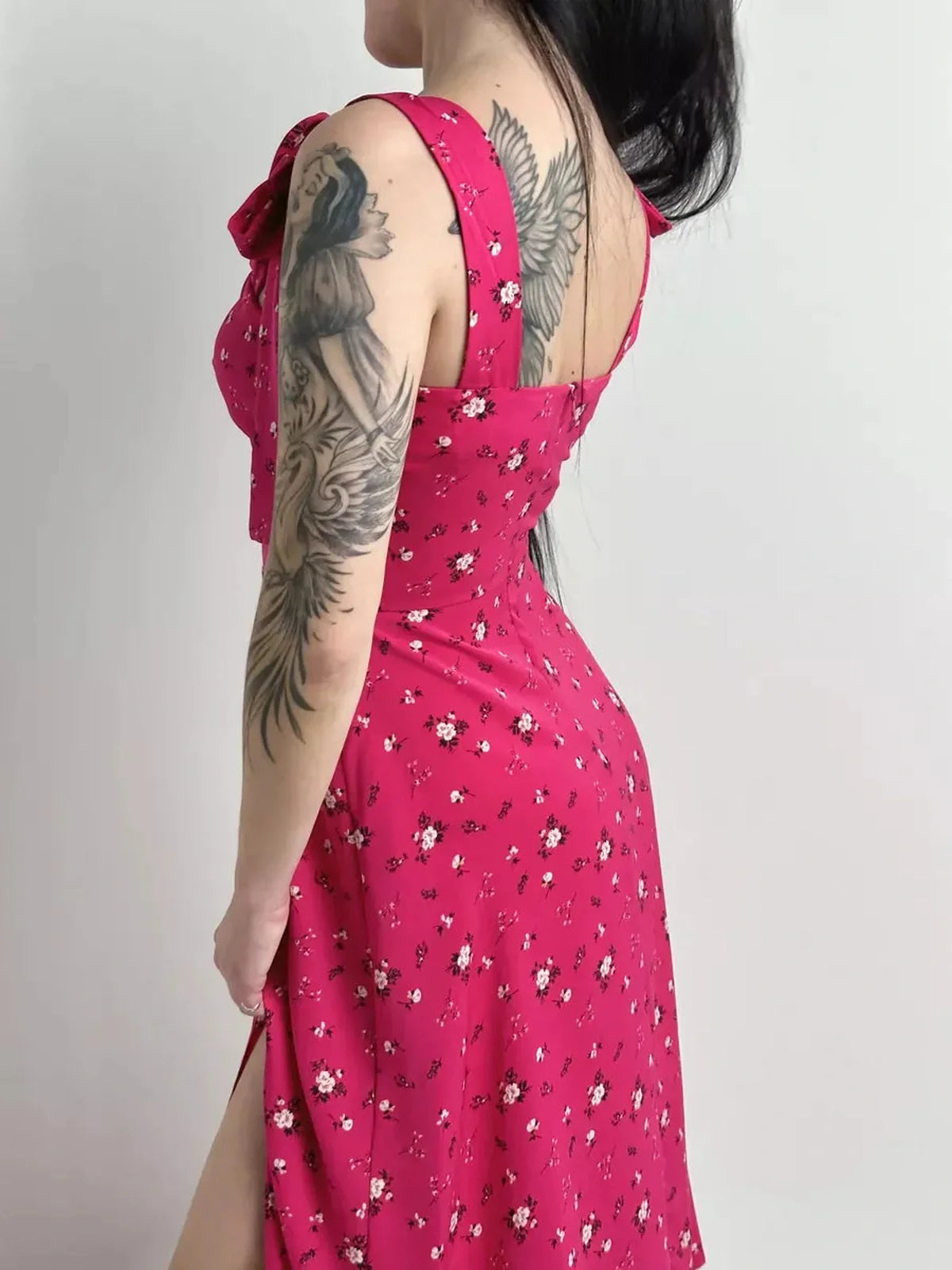 Model wearing the Rosé Charm Midi Dress featuring a vibrant pink floral print and adjustable shoulder ties.