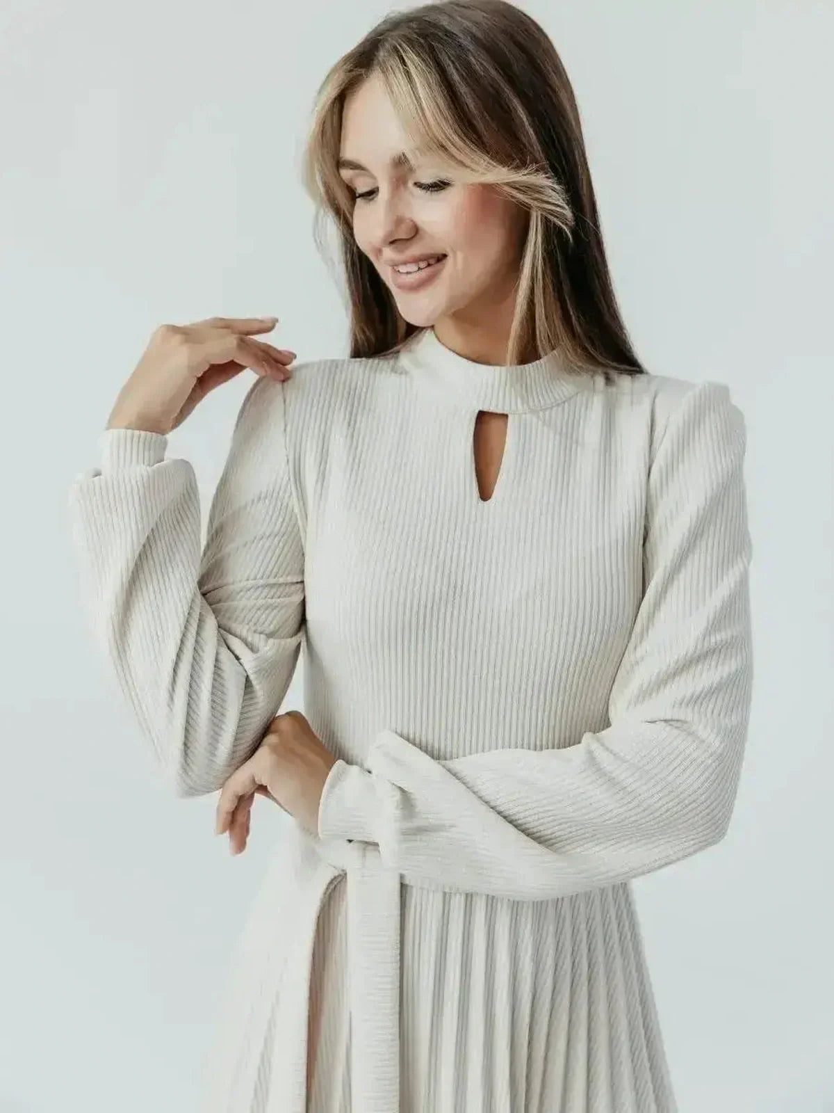 Model wearing the elegant Grace Pleat Midi Dress, showcasing a high neck and keyhole cutout in soft ribbed knit.
