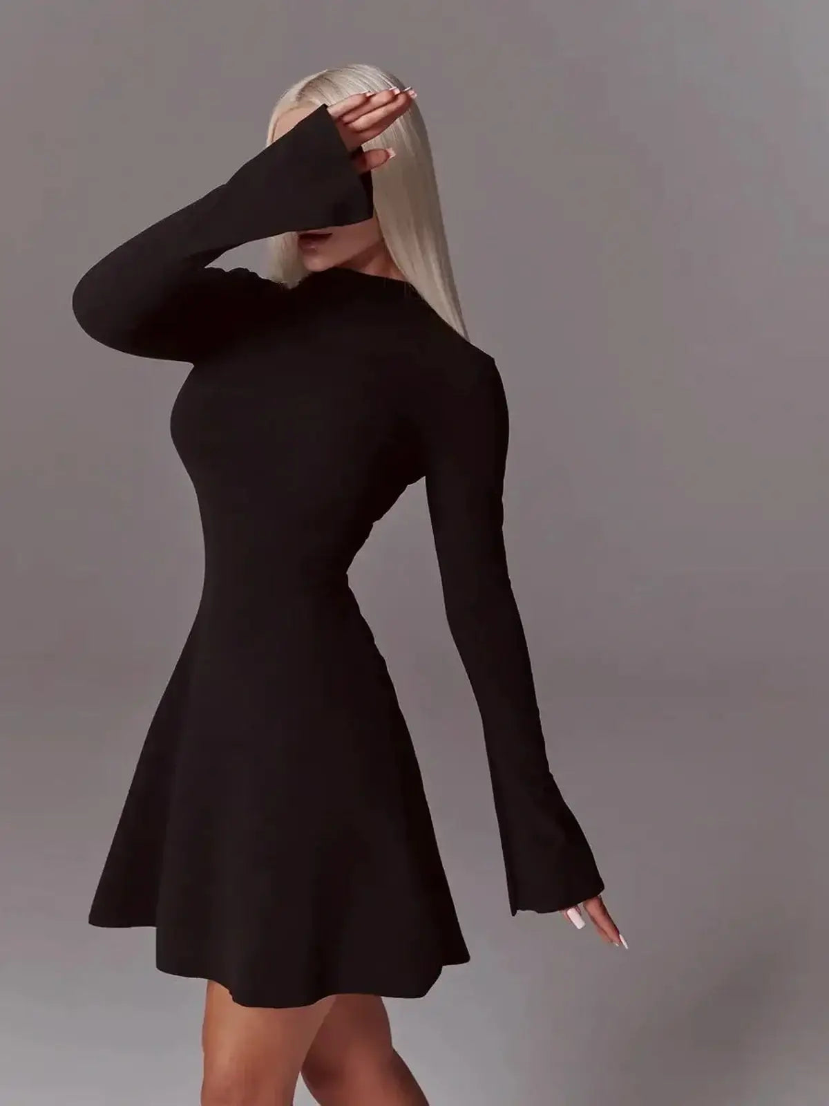 Elegant black mini dress with long flared sleeves and high neck, perfect for formal events or evening wear.
