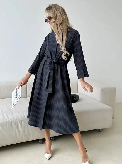 Slate Stripe Midi Dress featuring a relaxed fit, soft waist tie, and vertical pinstripes, perfect for versatile occasions.