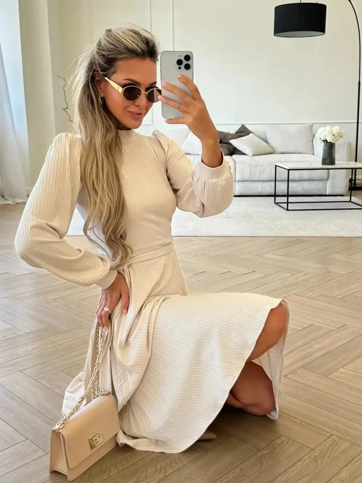 Model showcasing an Ivory Whisper Midi Dress with ribbed knit texture, styled with sunglasses and a handbag.