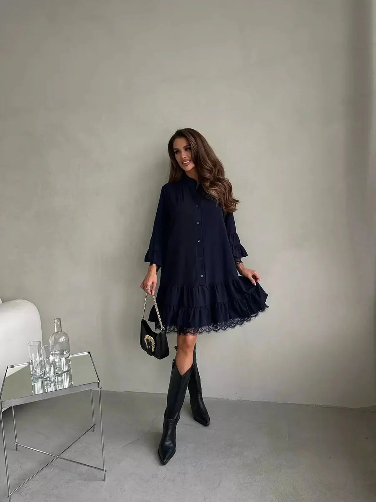 Navy blue lace flare mini dress with ruffle details, styled with knee-high boots and a chic handbag.
