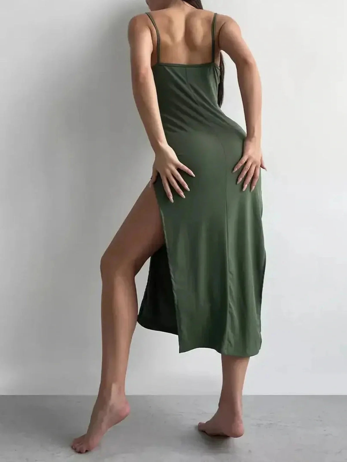 Woman showcasing the Verde Curve Midi Dress with a sleek silhouette and thigh-high slit, perfect for summer events.